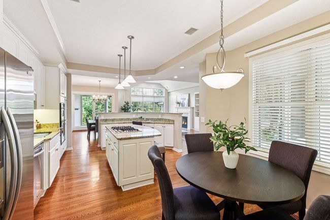 Classic white kitchen with modern amenities, including built-in ovens and a functional island workspace. | Image 14
