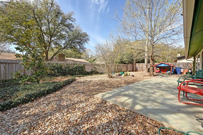 Yard designed for easy care with an oak tree providing shade. | Image 23