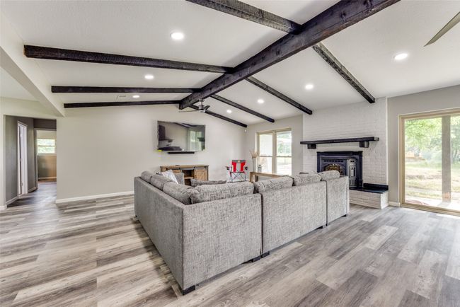 Living area featuring plenty of natural light, light wood-style floors, recessed lighting, and a brick fireplace | Image 11