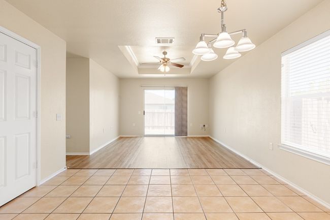 Unfurnished room featuring a tray ceiling, a ceiling fan, and light wood-type flooring | Image 14