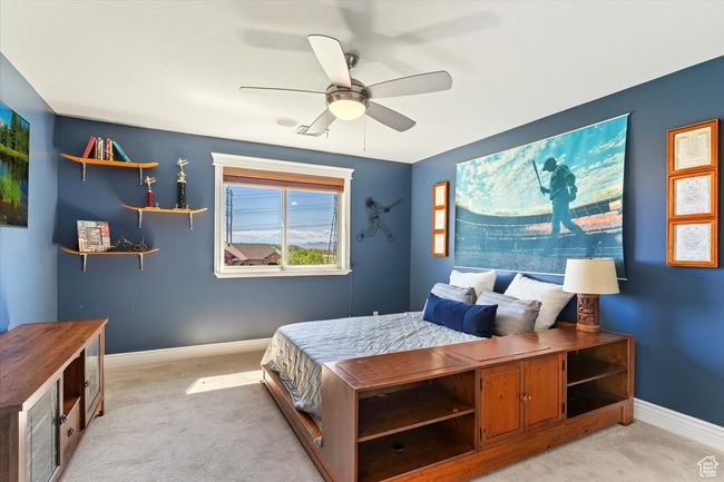 Bedroom featuring baseboards, light colored carpet, and ceiling fan | Image 40