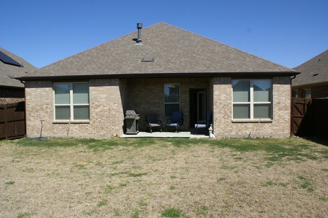 Rear view of property with brick back of house fenced backyard, and a patio area | Image 20
