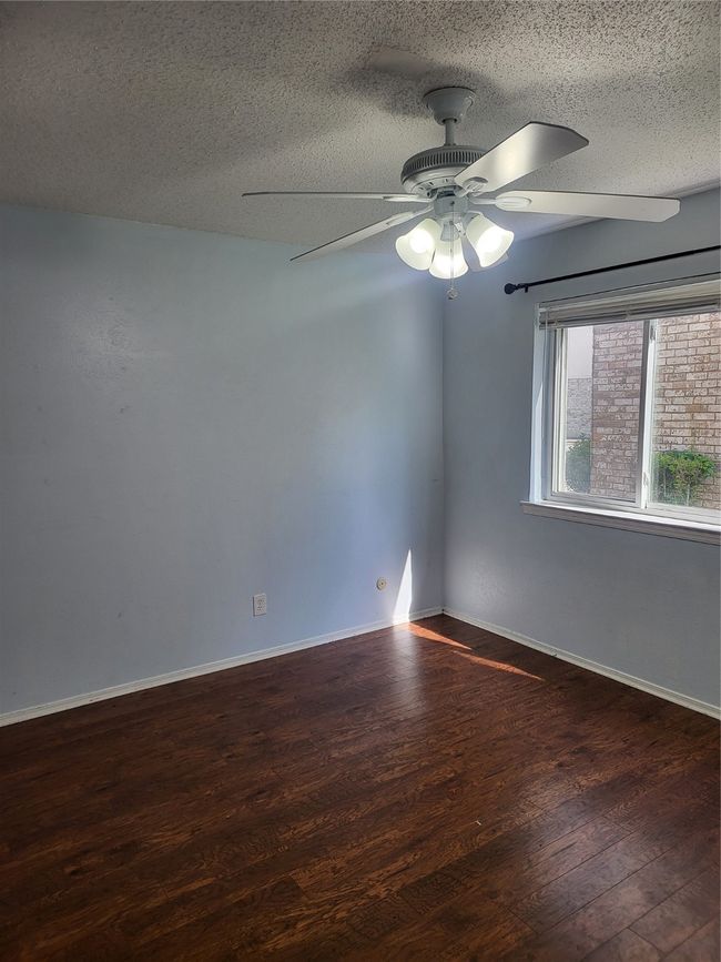 Unfurnished room with wood finished floors, a textured ceiling, and ceiling fan | Image 14