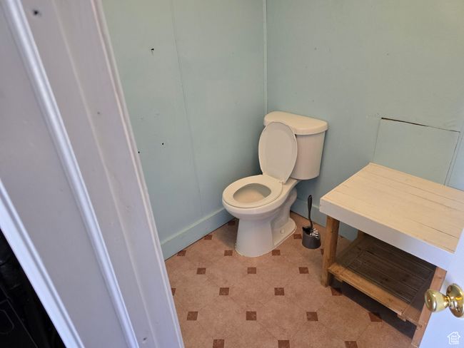 Bathroom with toilet, tile patterned floors, and baseboards | Image 13