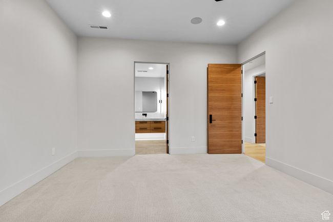 Unfurnished bedroom with ensuite bath, visible vents, carpet, and recessed lighting | Image 46