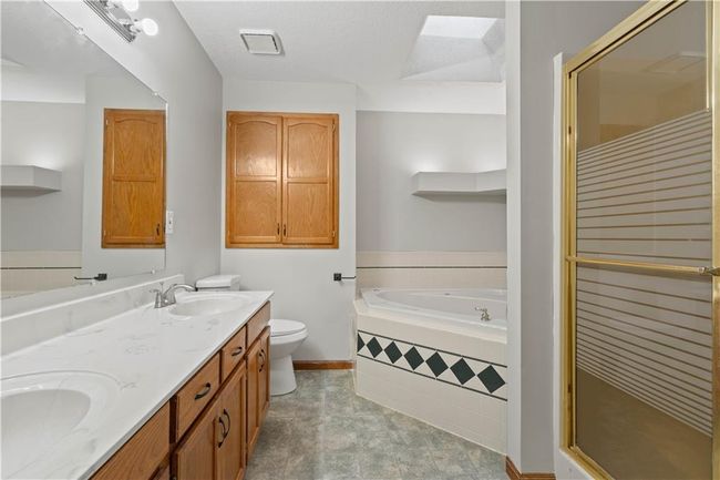 Full bath featuring a sink, a stall shower, double vanity, and a garden tub | Image 21