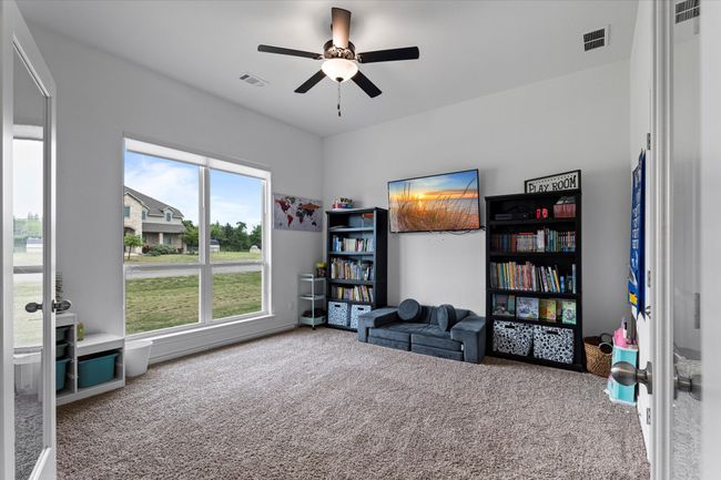Living area with visible vents, carpet flooring, and a ceiling fan | Image 7