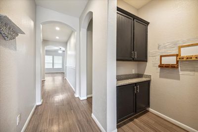 Upon entering the home the drop zone is to the right with its extra cabinets and the lower floor has laminate wood floors in all main living areas for easy care. | Image 2