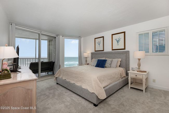 Primary bedroom with sliding door out to the ocean front balcony | Image 16