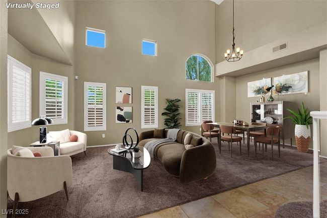 Carpeted living area featuring a chandelier and a high ceiling | Image 5