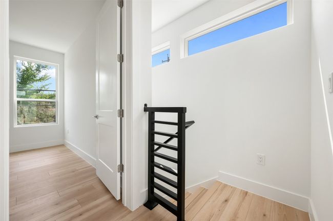 Hall with light wood finished floors, baseboards, and an upstairs landing | Image 19
