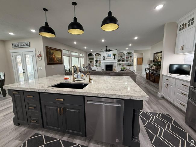 Kitchen with a center island with sink, a sink, white cabinets, and dishwasher | Image 21
