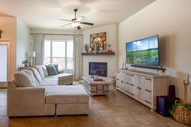 Living area featuring a glass covered fireplace and ceiling fan | Image 9