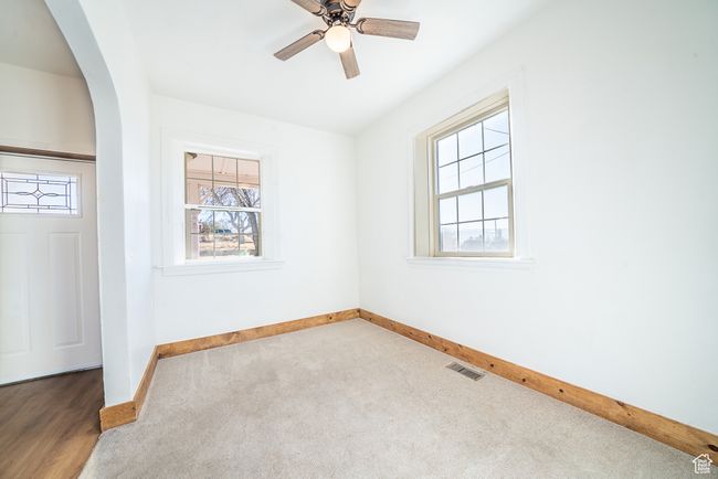 Spare room with baseboards, visible vents, arched walkways, a ceiling fan, and carpet flooring | Image 18