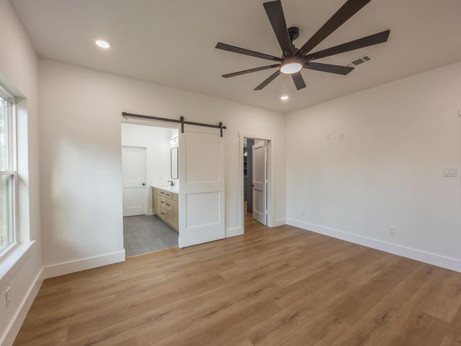 A custom sliding barn door separates the bedroom from the ensuite bath, blending rustic charm with modern convenience for a seamless, private retreat. | Image 21
