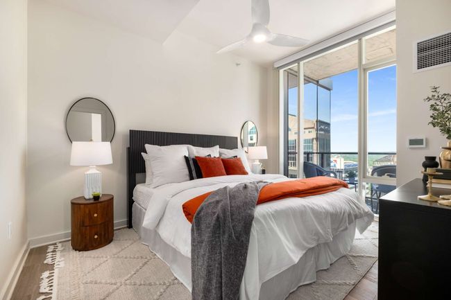 The primary suite easily accommodates a king-sized bed and two side tables, offering northward views over the private balcony. | Image 26