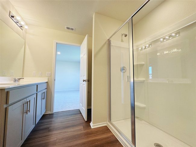 Full bathroom featuring a stall shower, vanity, wood finished floors, and baseboards | Image 18