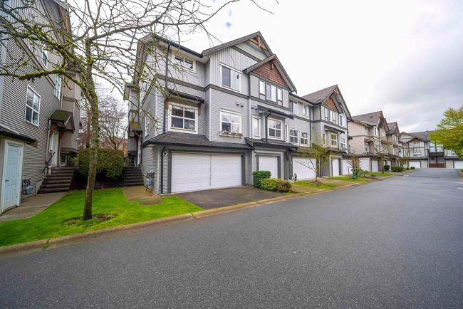 Exterior space with an attached garage, aphalt driveway, and a residential view | Image 39