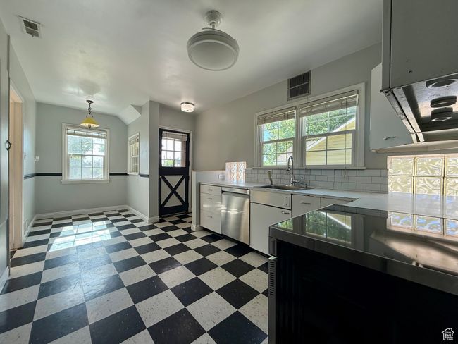 Kitchen featuring dishwasher, a sink, light floors, light countertops, and backsplash | Image 15