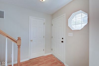 Step inside the main foyer, and you'll find hardwood floors, a half bathroom, and the main stairway. | Image 2