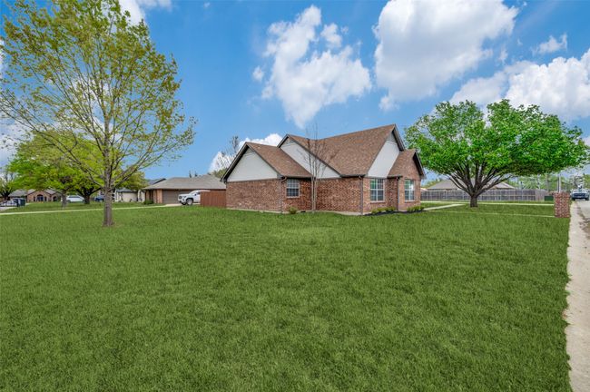 View of home's exterior featuring roof with shingles, a yard, brick siding, and fence | Image 29