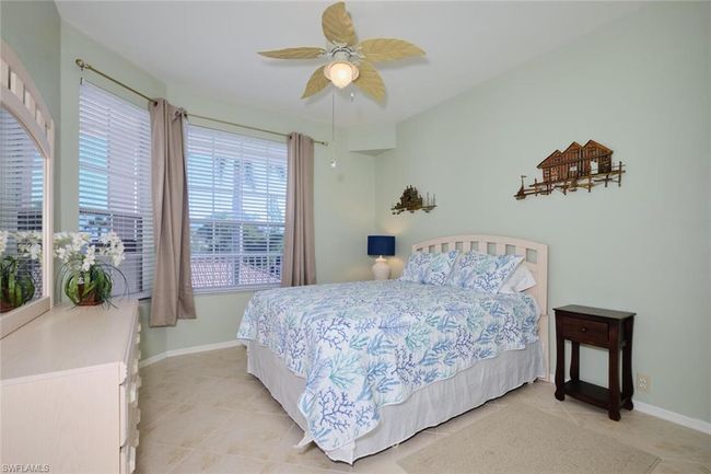 Bedroom with ceiling fan and light tile patterned floors | Image 41