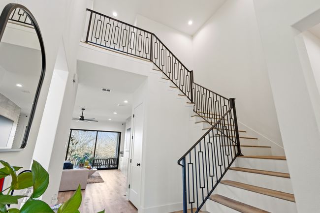 Stairway with a ceiling fan, a towering ceiling, wood finished floors, and recessed lighting | Image 16