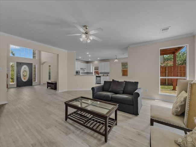 Living room featuring plenty of natural light, ornamental molding, a ceiling fan, light wood finished floors, and recessed lighting | Image 5