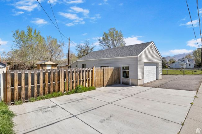 Garage with a mountain view, driveway, and fence | Image 54