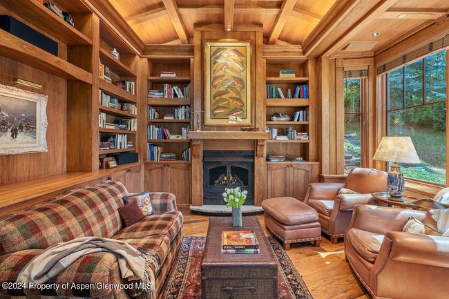 A intimate space for reading and TV, with views of river. Gas fireplace. TV is in a disappearing pop-up behind sofa. | Image 15