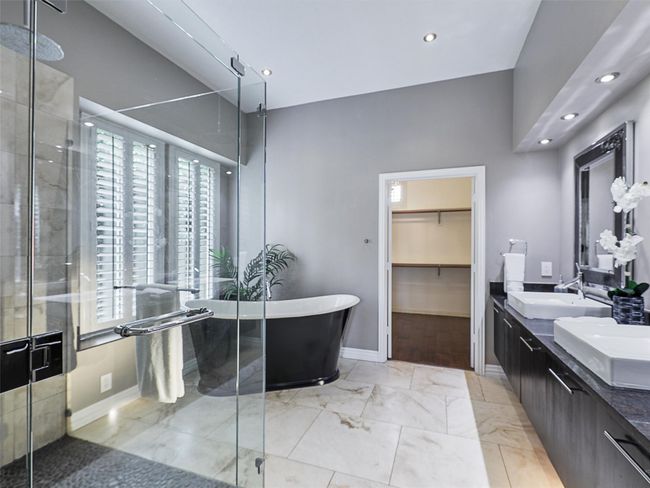 Bathroom with double vanity, a freestanding tub, a shower stall, recessed lighting, and marble finish flooring | Image 25