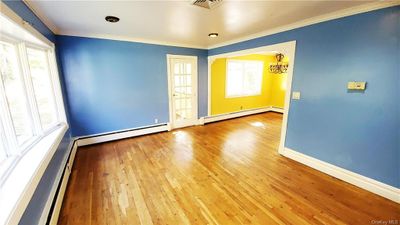 Unfurnished room with plenty of natural light, baseboard heating, and light wood-type flooring | Image 3