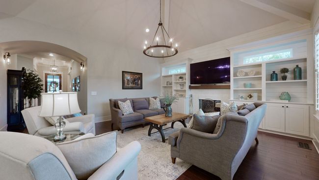 Cozy meets elegant in this living room—featuring a vaulted ceiling, custom built-ins, shiplap accents, and a fireplace that anchors the space beautifully for relaxing nights w/family or hosting guests in style. | Image 23