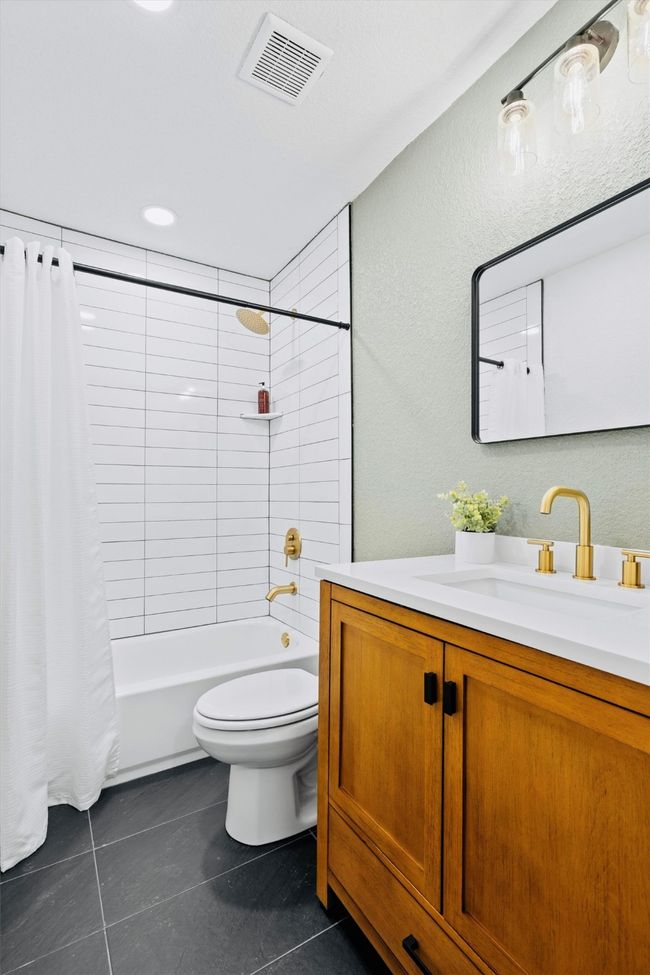 Bathroom featuring tile patterned floors, vanity, and shower / bath combo with shower curtain | Image 33