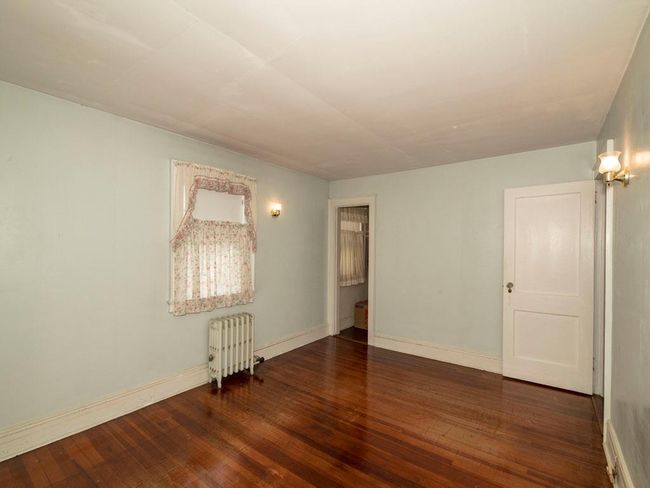 Spare room featuring radiator heating unit and wood-type flooring | Image 25