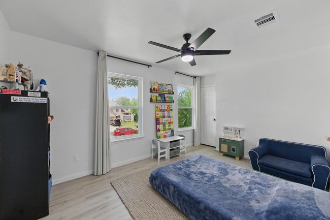 The cozy guest bedrooms feature fresh, modern updates, including ceiling fans for added comfort. | Image 22