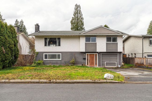 View of front of house featuring an attached garage, a chimney, aphalt driveway, and fence | Image 40