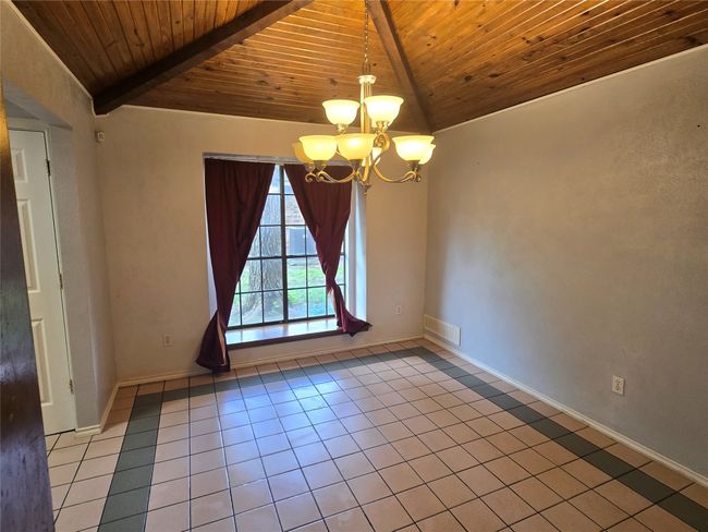 Tiled spare room with wooden ceiling and a chandelier | Image 9