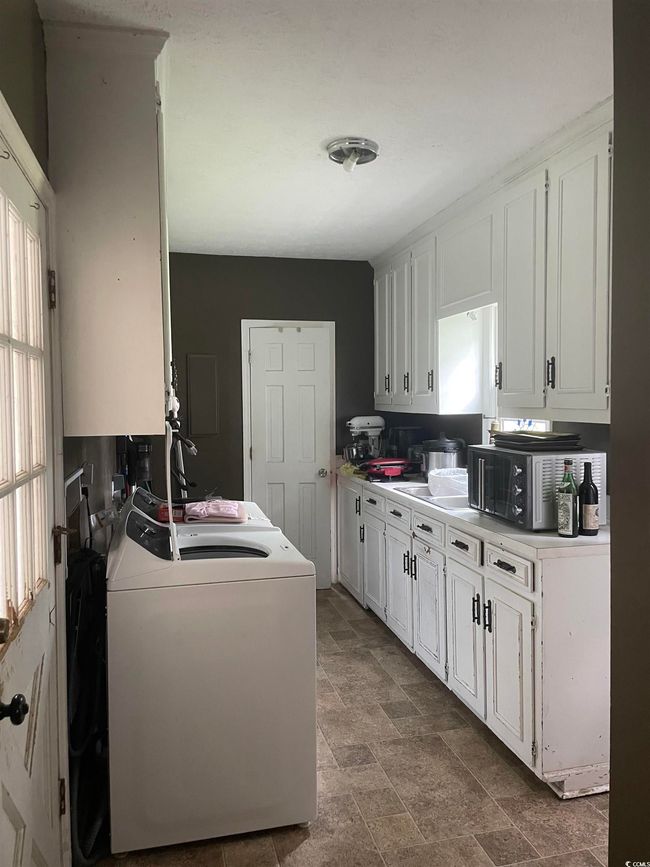 Laundry room featuring washer / dryer and stone finish flooring | Image 21