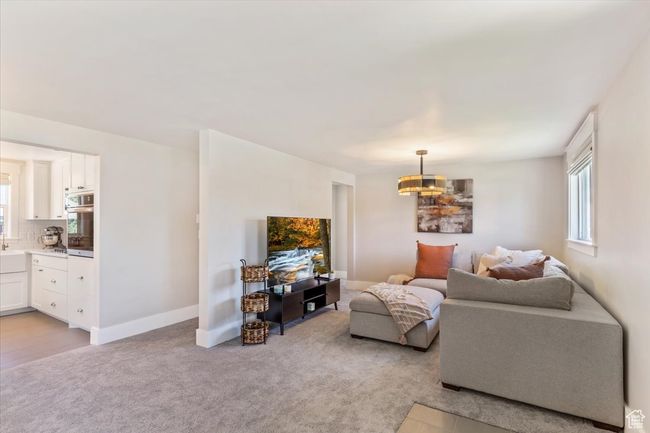 Living room featuring light colored carpet and a chandelier | Image 6