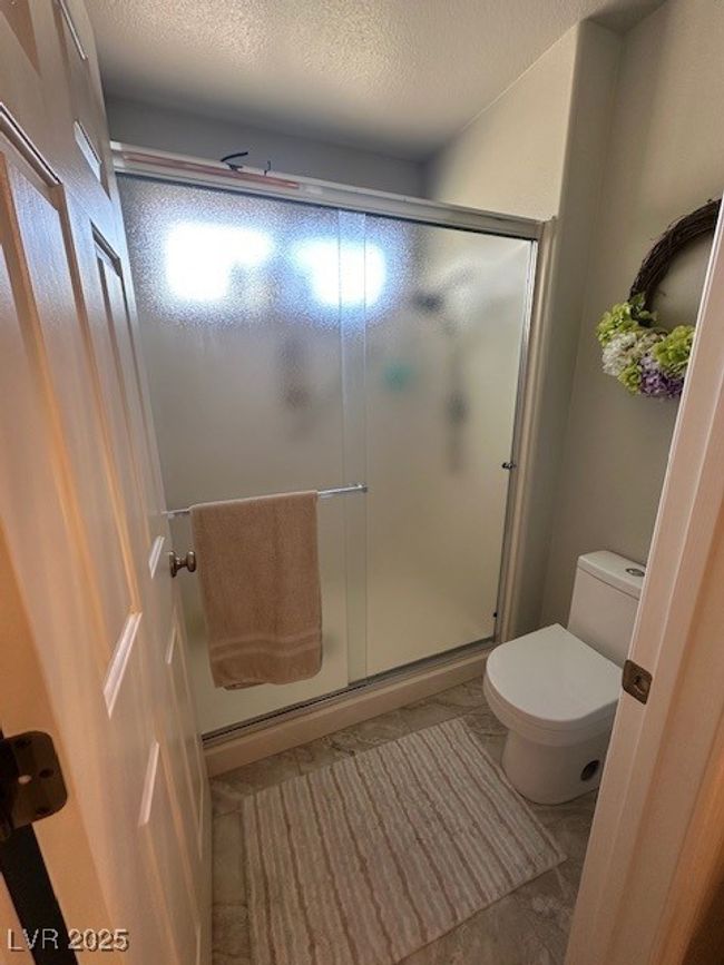 Full bath featuring a shower stall and a textured ceiling | Image 8
