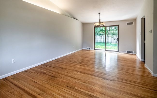The spacious feel of the living area is accentuated by a vaulted ceiling and a sliding glass door that allows ample natural light. | Image 5