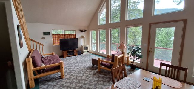 Carpeted living room with stairs and high vaulted ceiling | Image 26