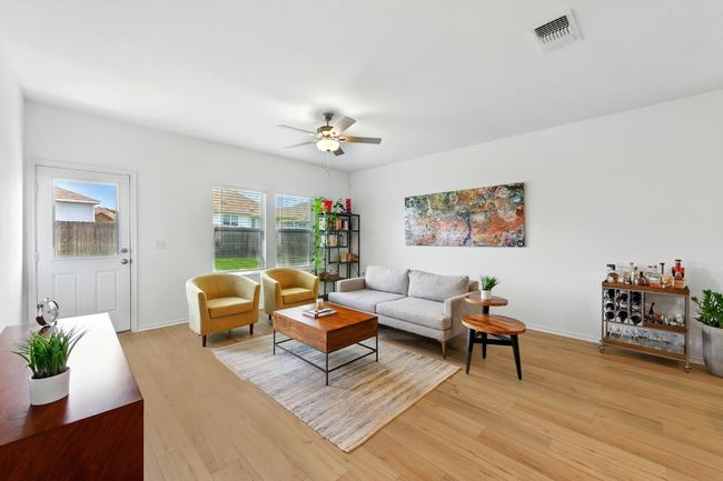 Living area featuring light wood-type flooring, a ceiling fan, and baseboards | Image 7