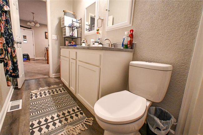 Bathroom featuring toilet, wood finished floors, vanity, and a textured wall | Image 30