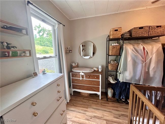 Bedroom with light wood finished floors and ornamental molding | Image 11