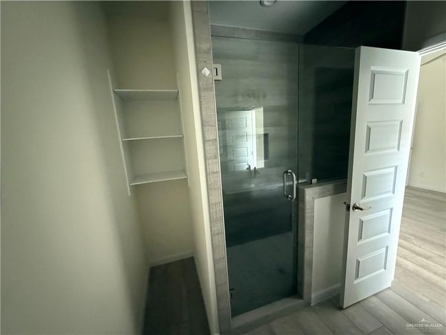 Bathroom with a shower stall, wood finished floors, and baseboards | Image 11
