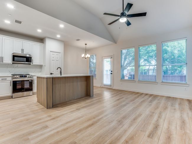 Kitchen featuring appliances with stainless steel finishes, a chandelier, light countertops, light wood-type flooring, and recessed lighting | Image 7
