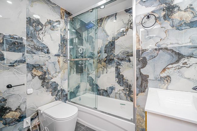 Bathroom with combined bath / shower with glass door and vanity | Image 10