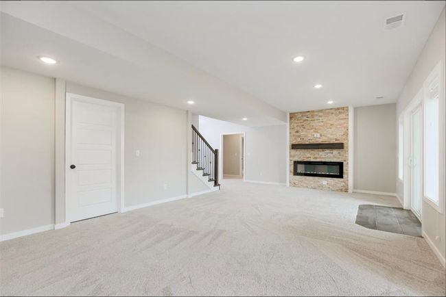 Unfurnished living room featuring carpet, stairway, a fireplace, recessed lighting, and baseboards | Image 14
